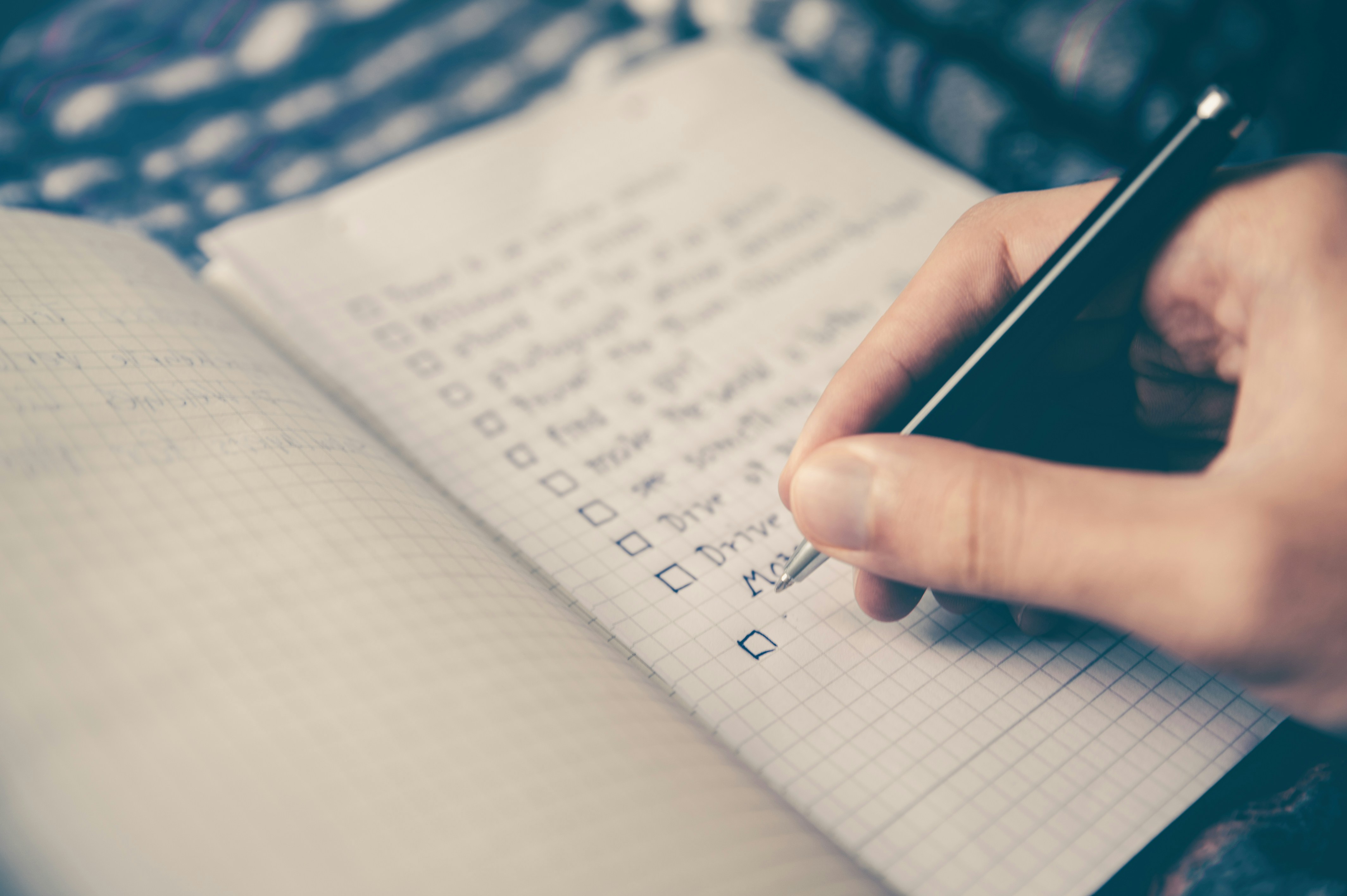 A blurred image showing a checklist in a a5 notebook